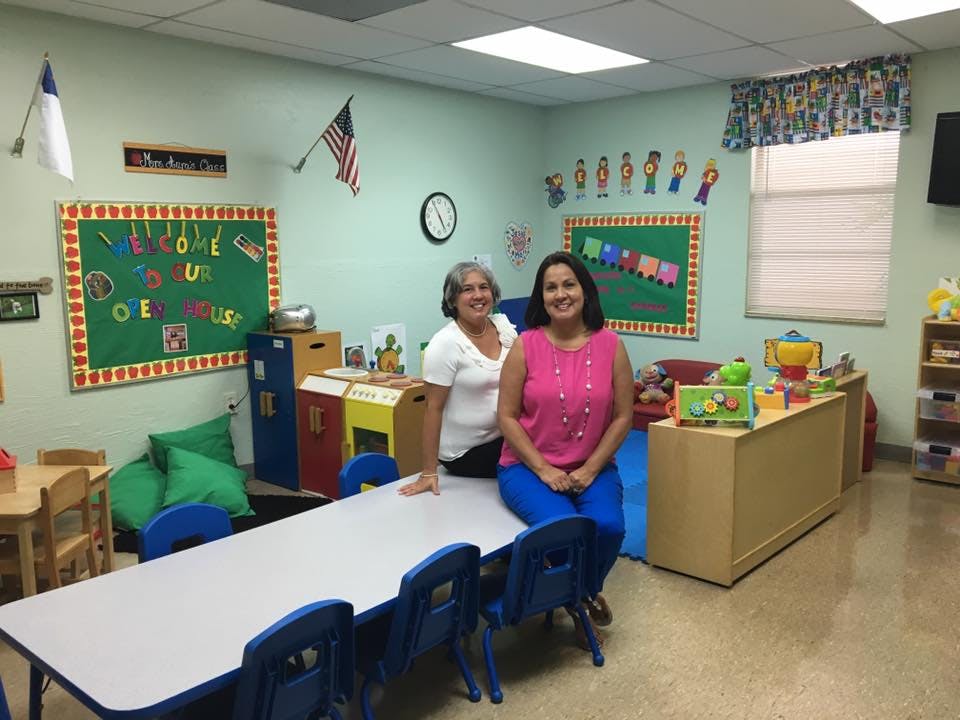 Two women posing in a classroom