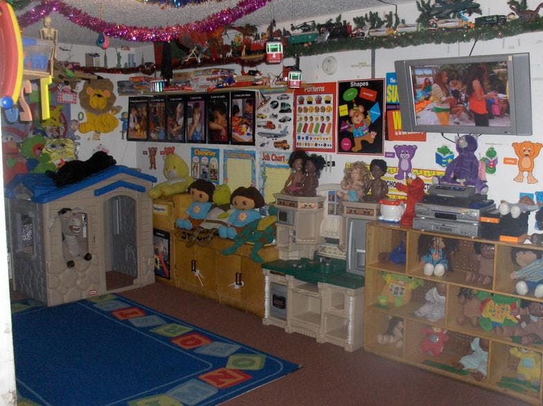 Playroom with a playhouse, shelves of toys, and a television