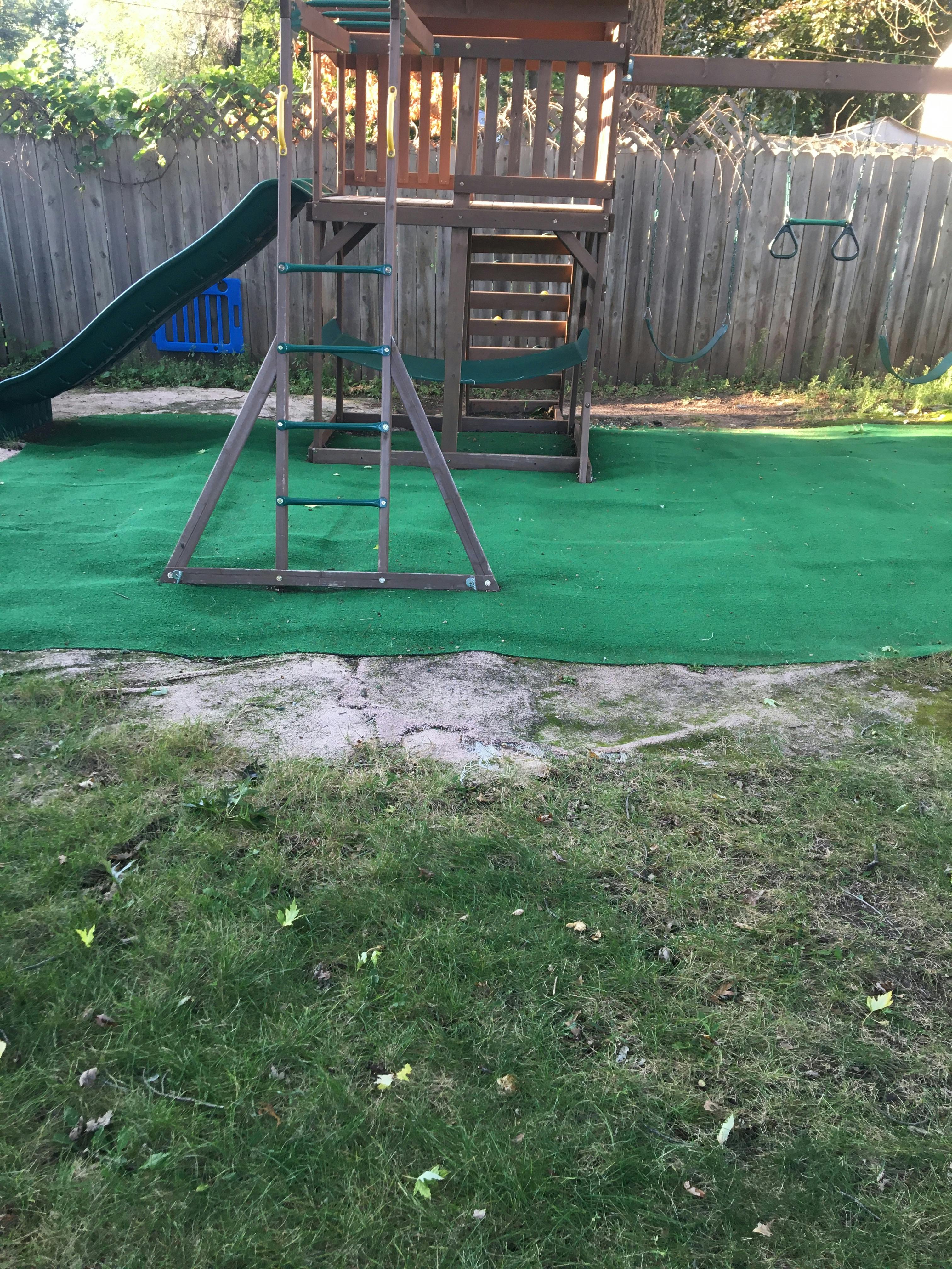 Wooden playground set with slide and swings on green turf