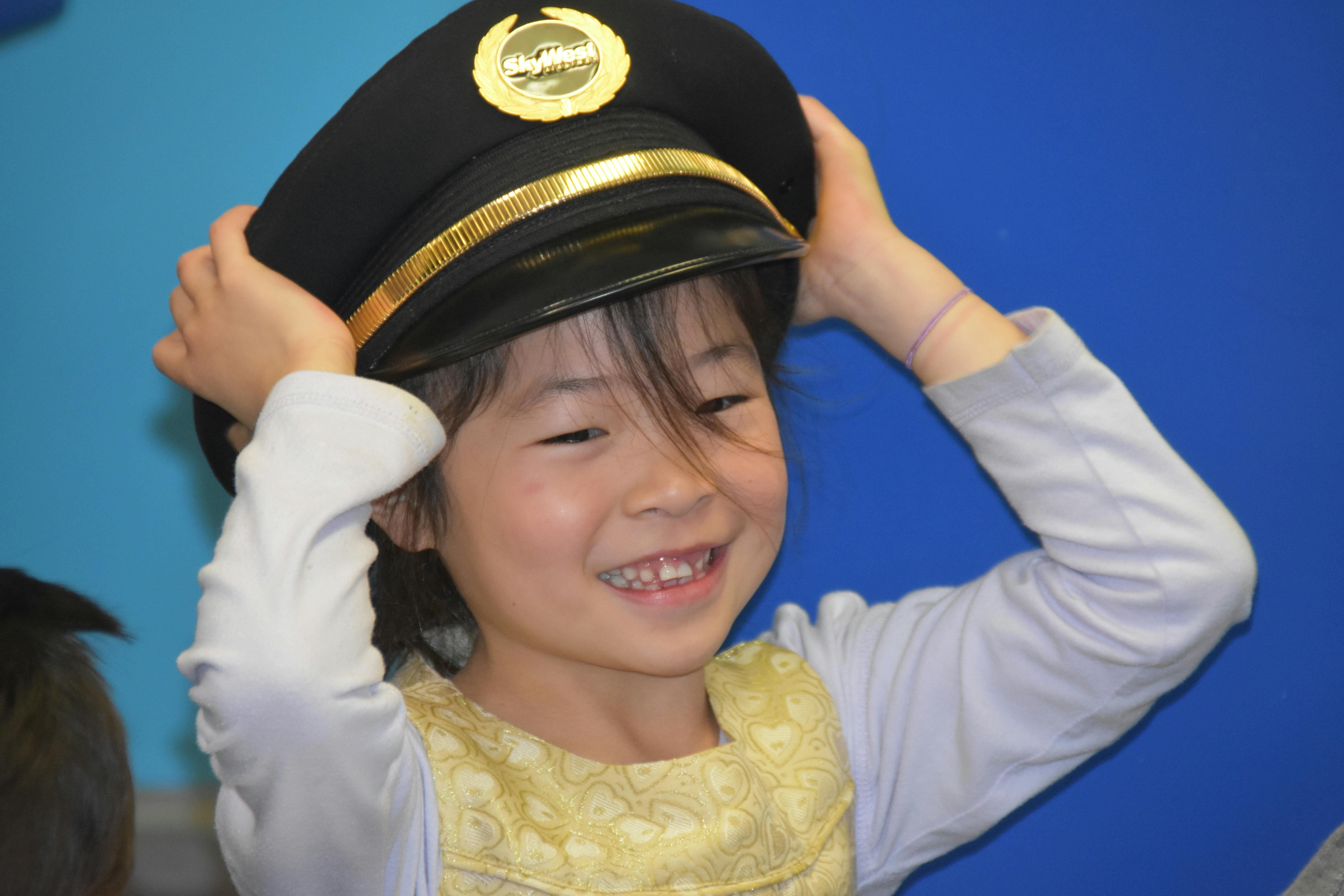 Child putting on a black and gold hat
