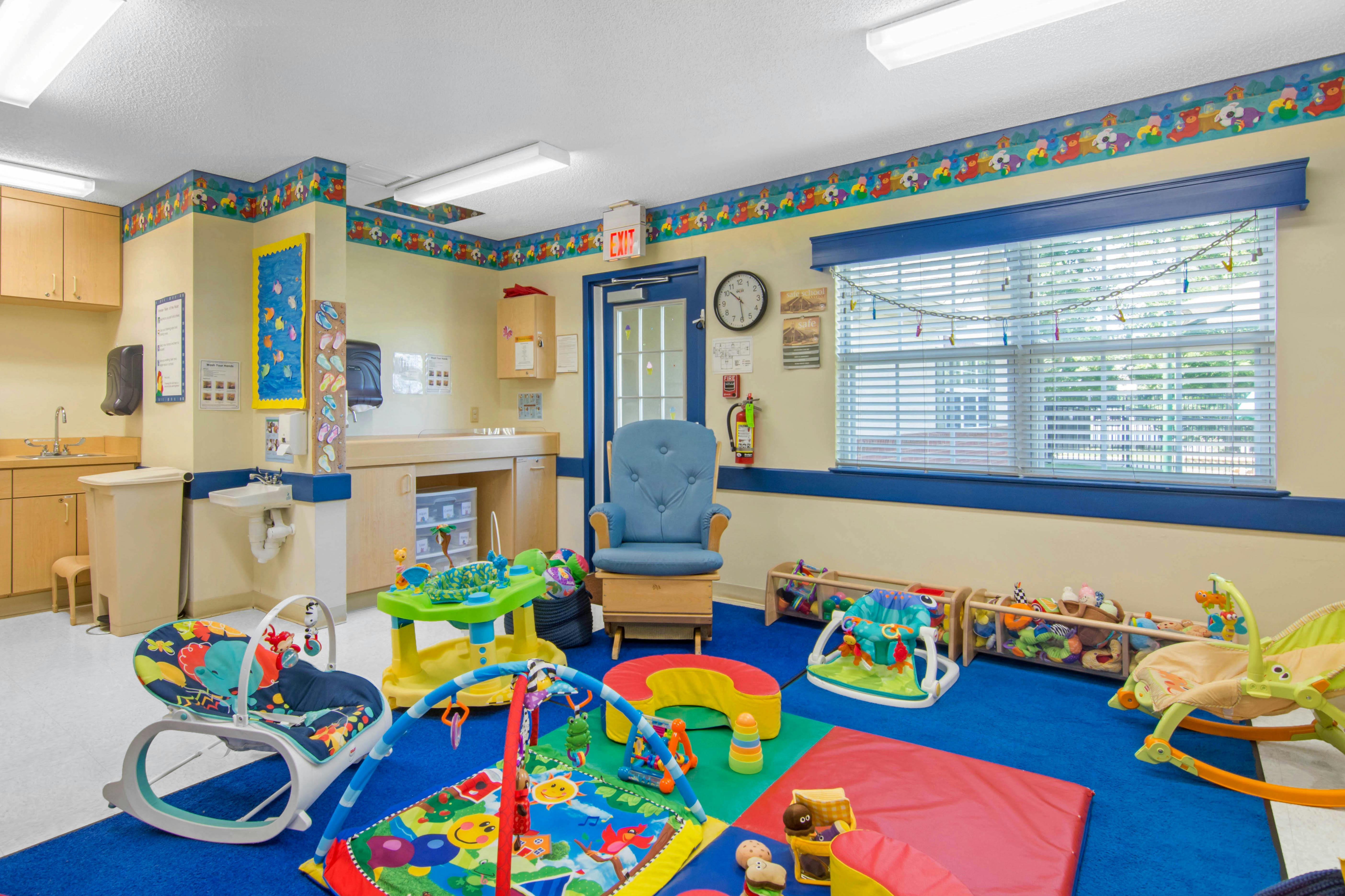 A baby classroom with multiple toys, furniture, and a changing station