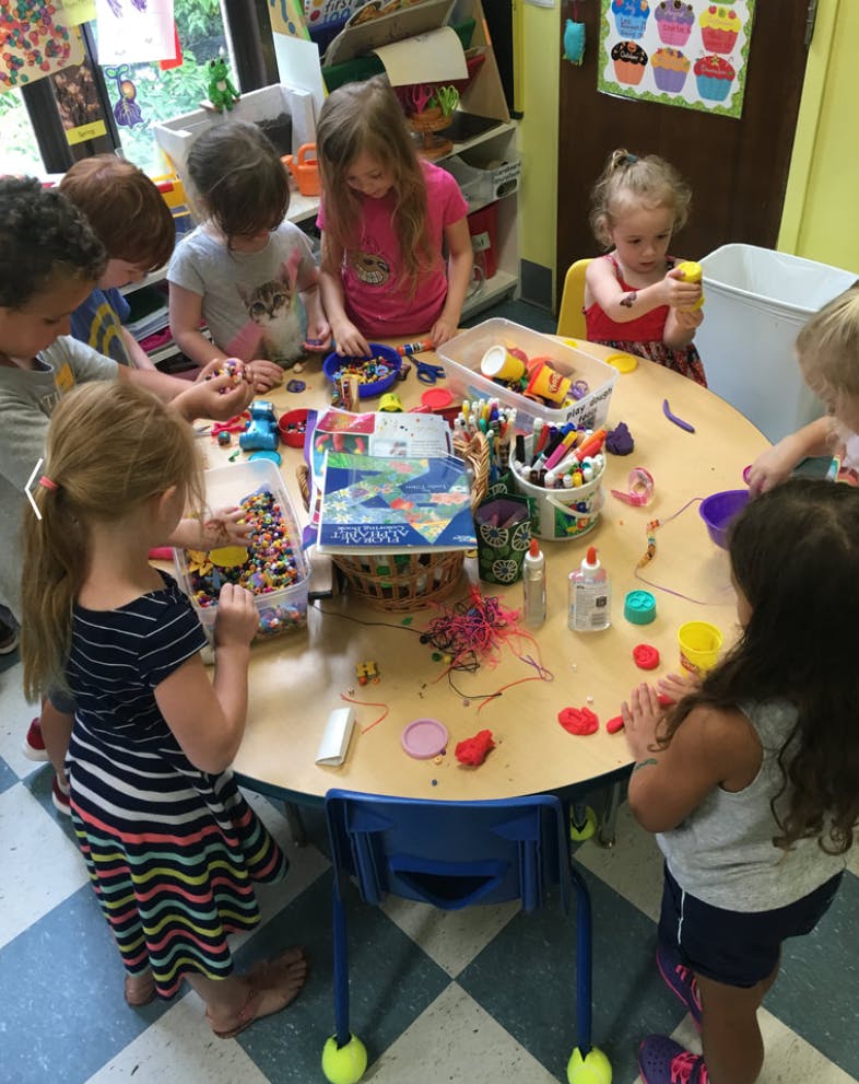 Children gathered around a table doing crafts