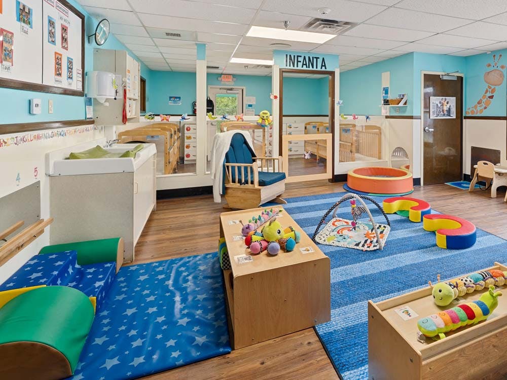 An empty infant classroom with changing tables and play areas