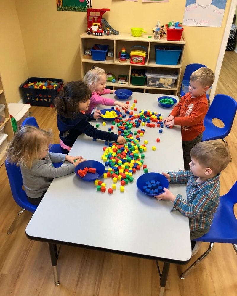 Children playing with colorful blocks at a table