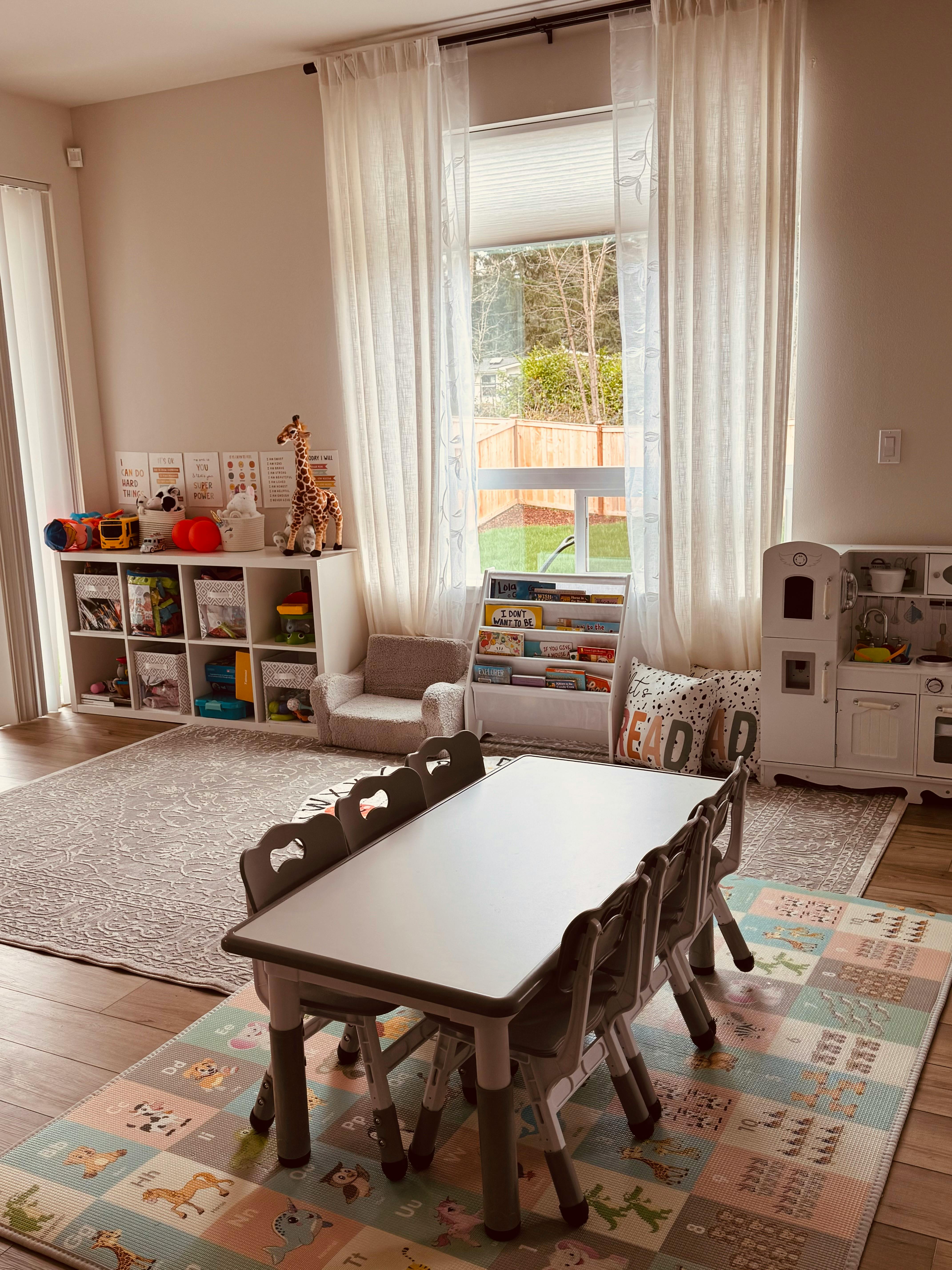 Playroom with small table and chairs, toy shelves, and window