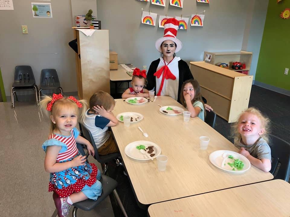 Person in Cat in the Hat costume with children at a table