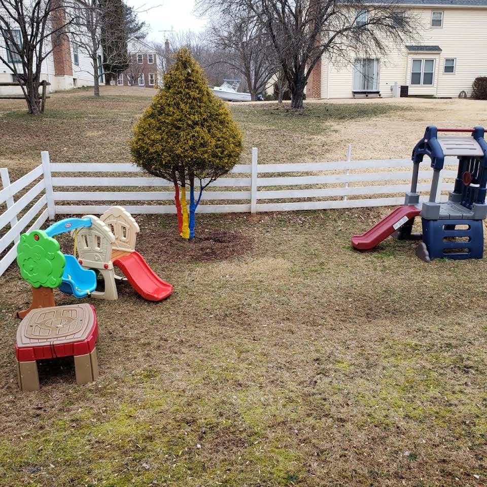 Backyard with a white fence and two plastic play structures