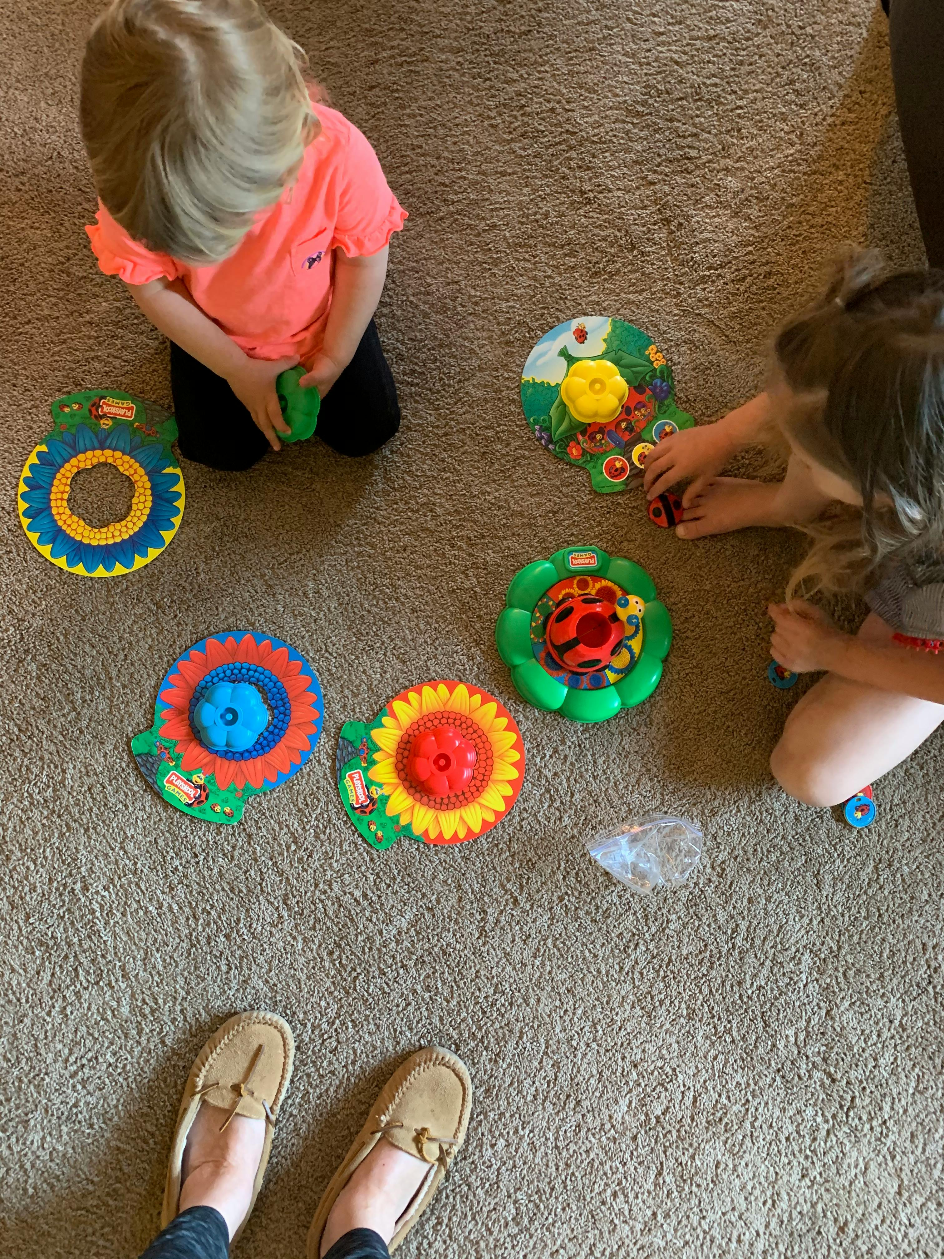 Two children playing with toys on a carpeted floor