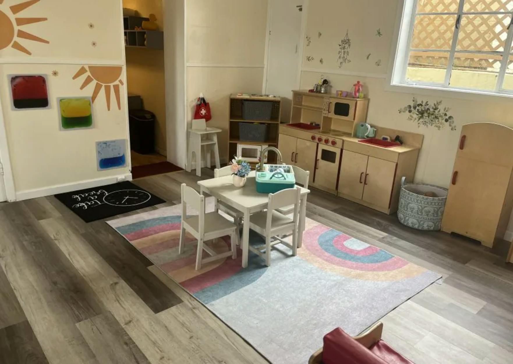Playroom with a small table, chairs, and toy kitchen furniture