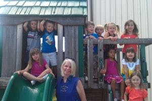 Adult and children on playground equipment