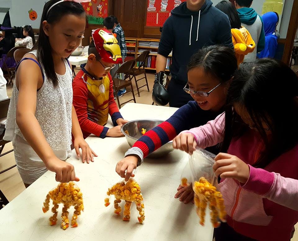 Children making crafts with orange snack food
