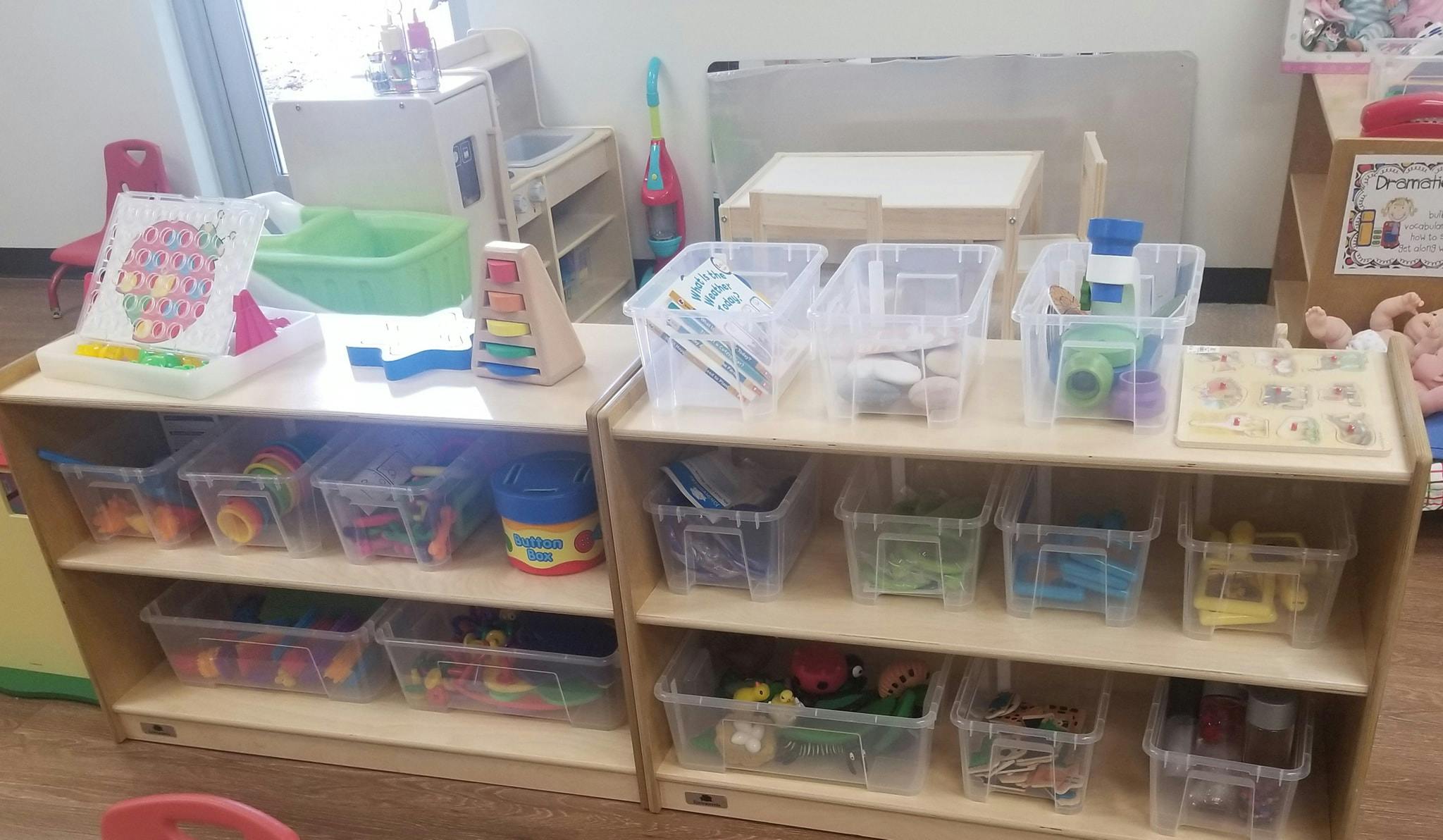 Shelves with clear bins of toys and learning materials in a classroom
