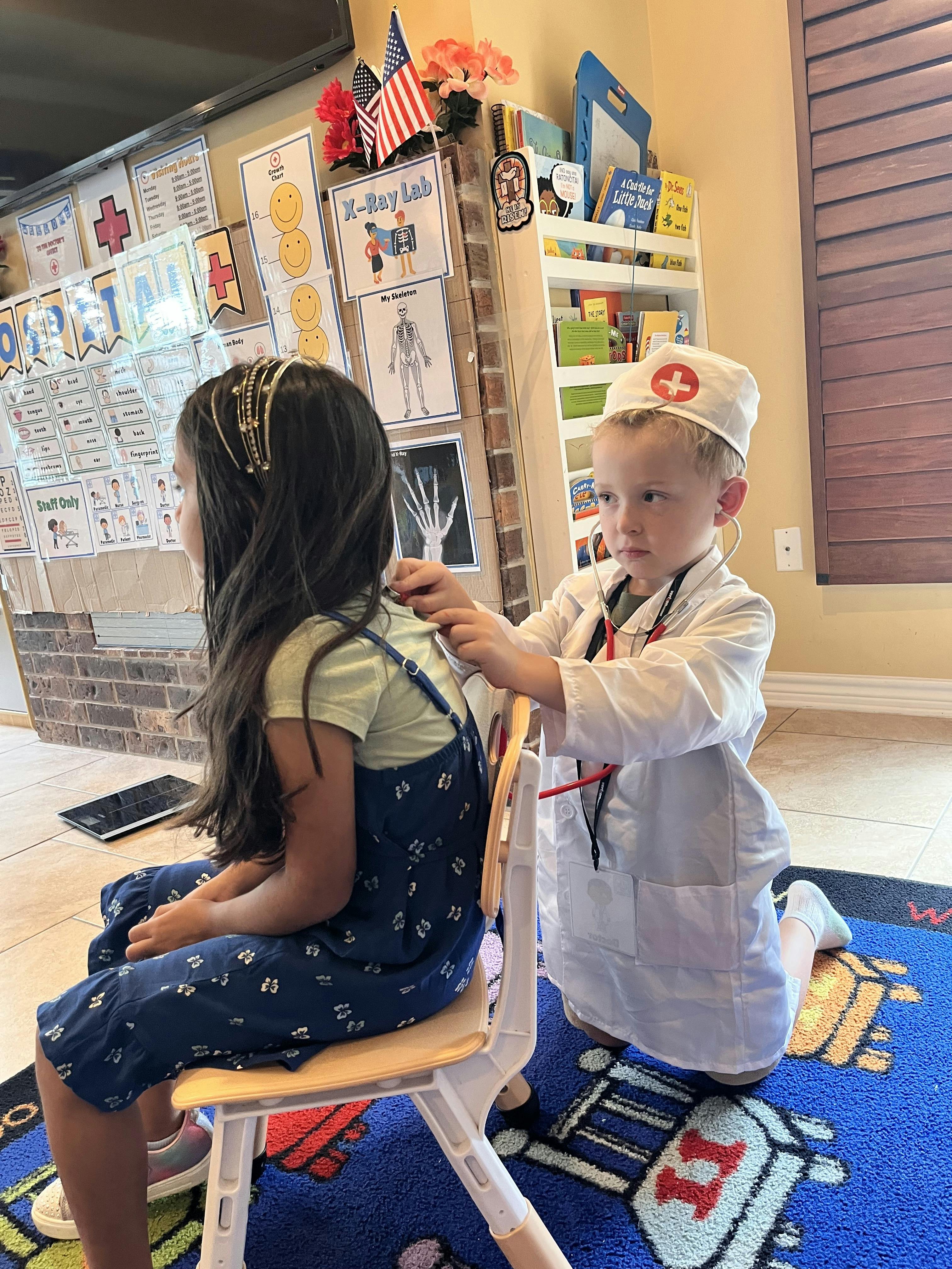 Child in doctor costume using a stethoscope on another child