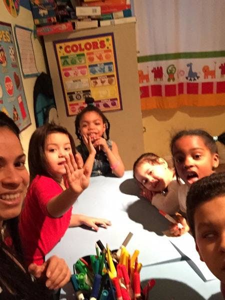 Adult and multiple children at a table with art supplies