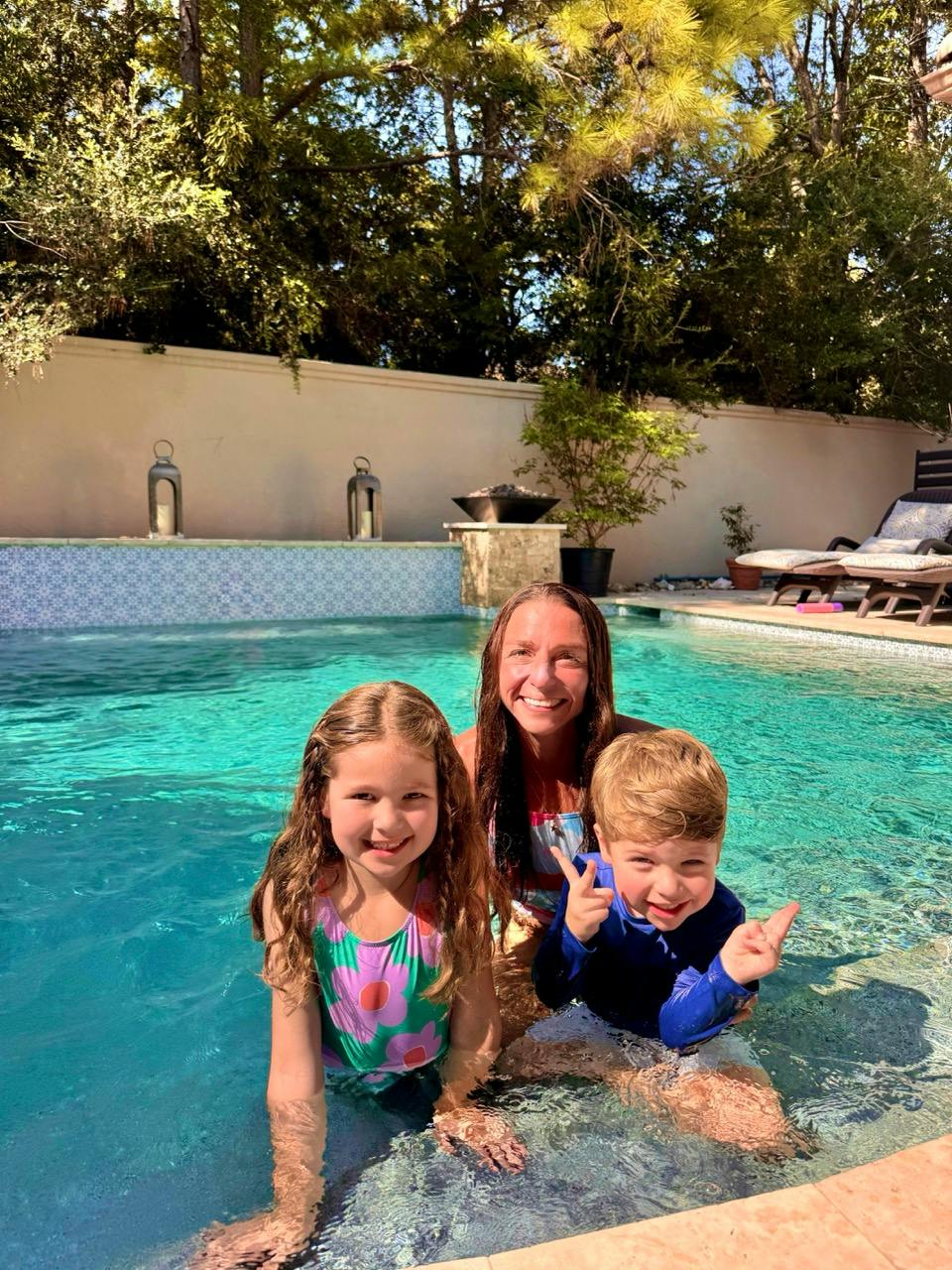 One adult and two children in a swimming pool