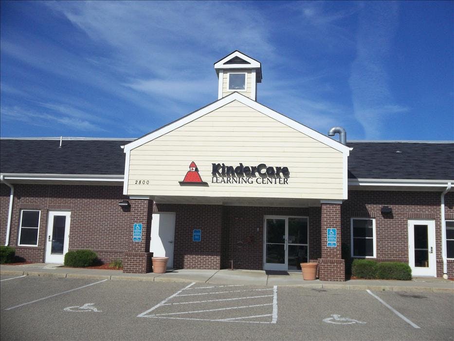 KinderCare Learning Center building with parking lot and bright blue sky
