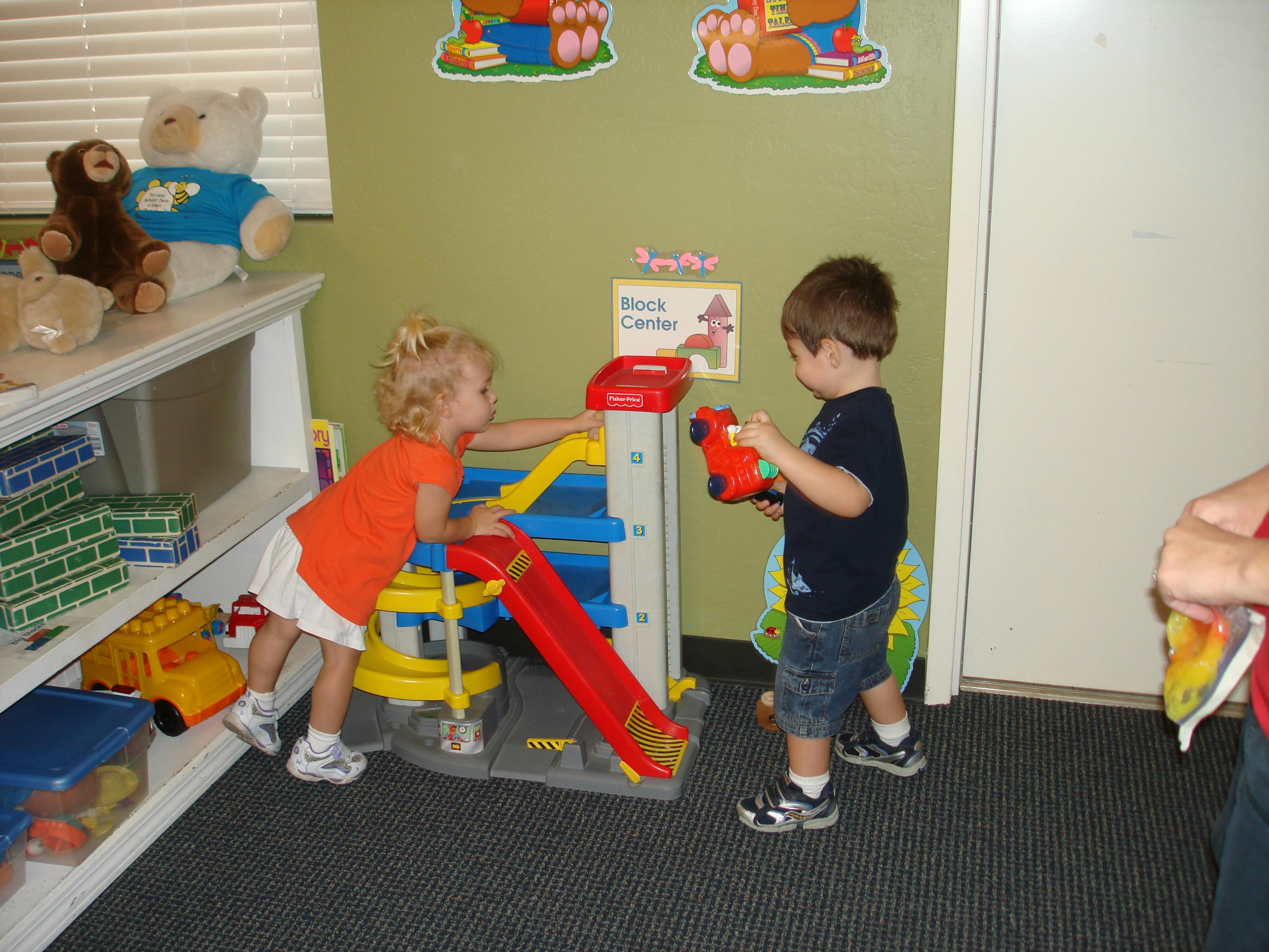 Two children playing with a toy garage