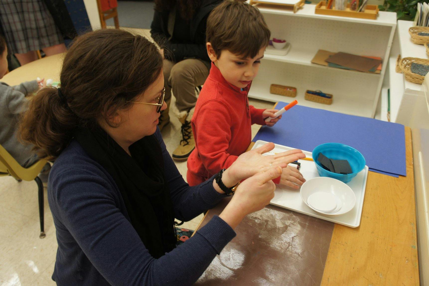 Person and child doing an activity at a table