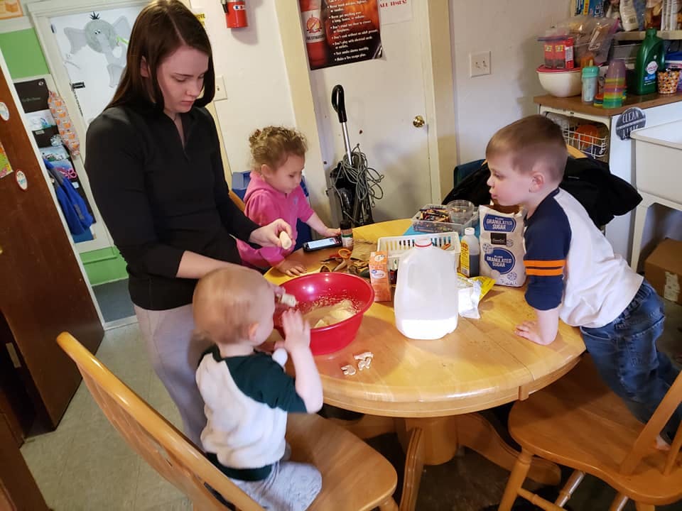 Person and three children at a table