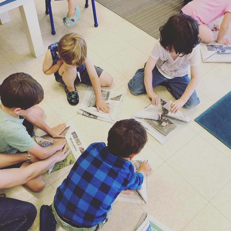 Children on floor with newspapers