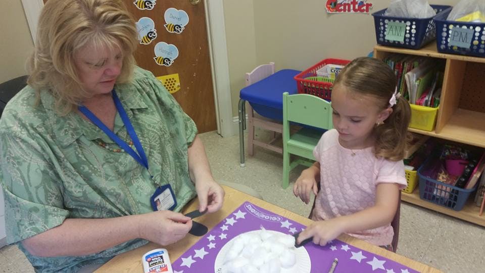Person and child doing a craft at a table