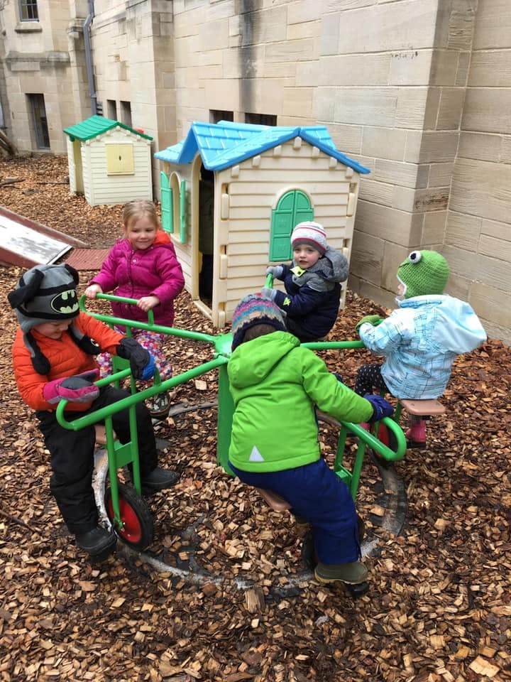Children playing on a merry-go-round in a playground