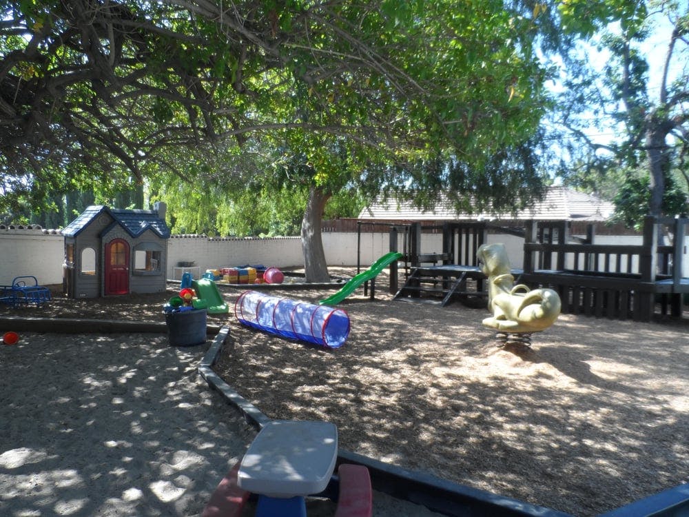 Outdoor playground with playhouse, slide, and tunnel