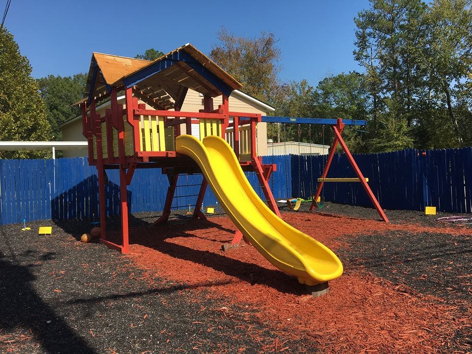 Playground with a yellow slide and swing set