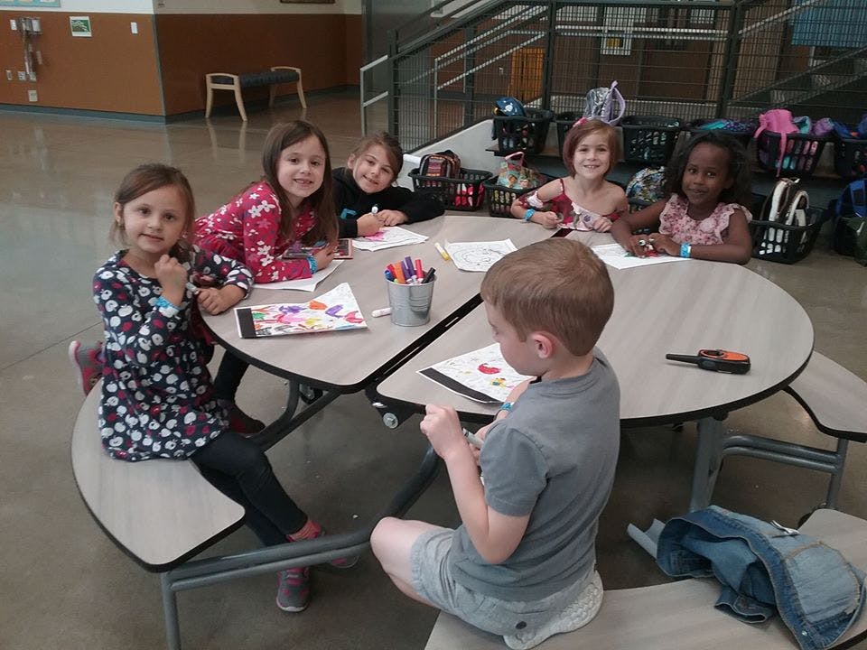 Children sitting at a table drawing and coloring