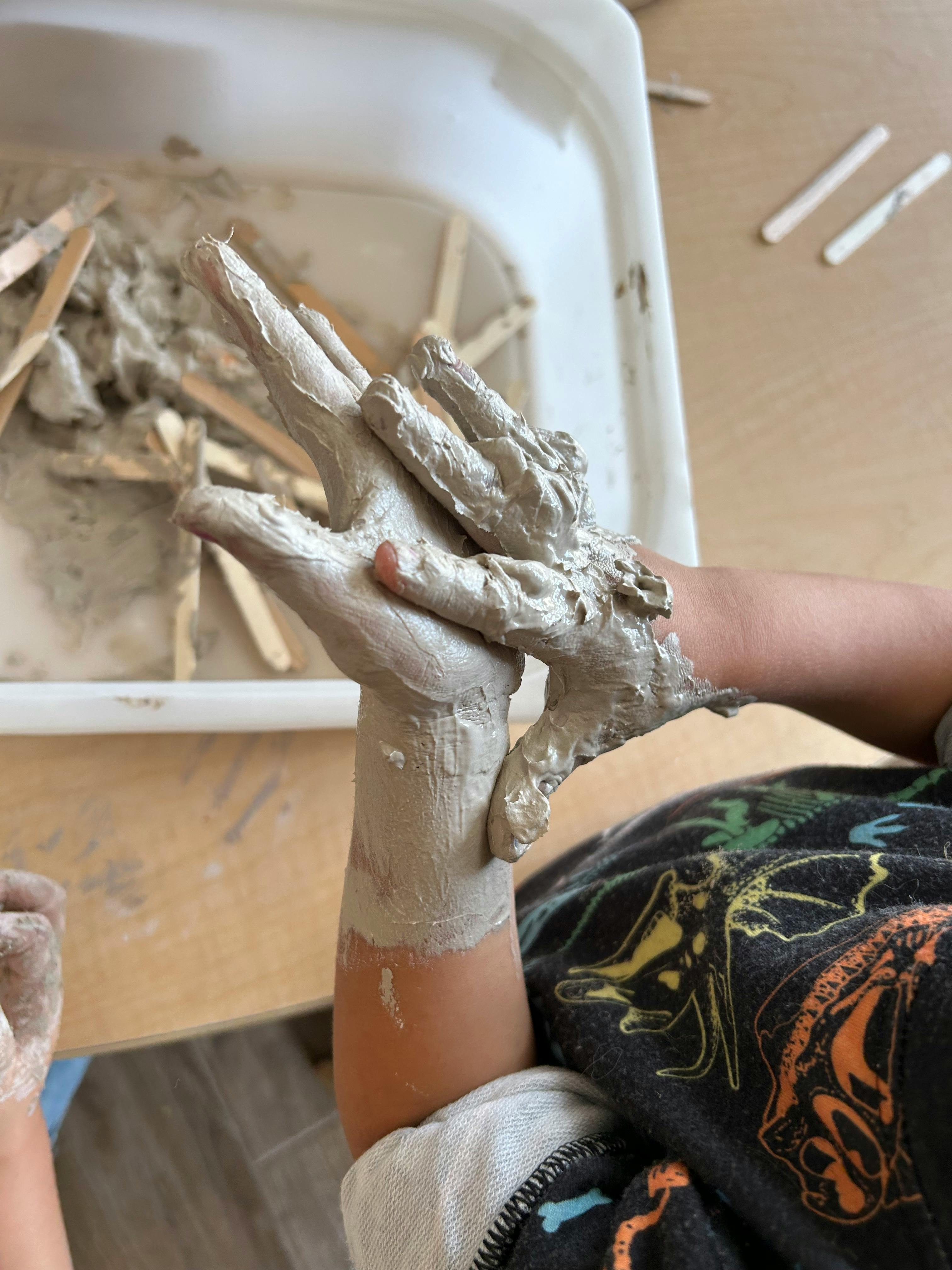 Child's hands covered in mud or playing with mud