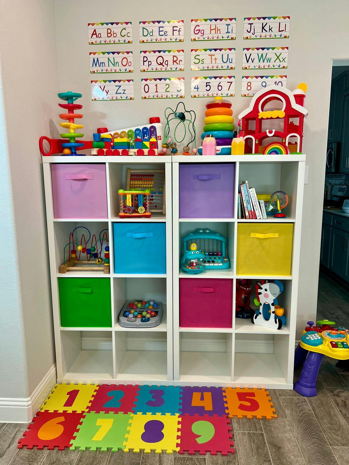 White shelving unit filled with colorful toys and storage bins