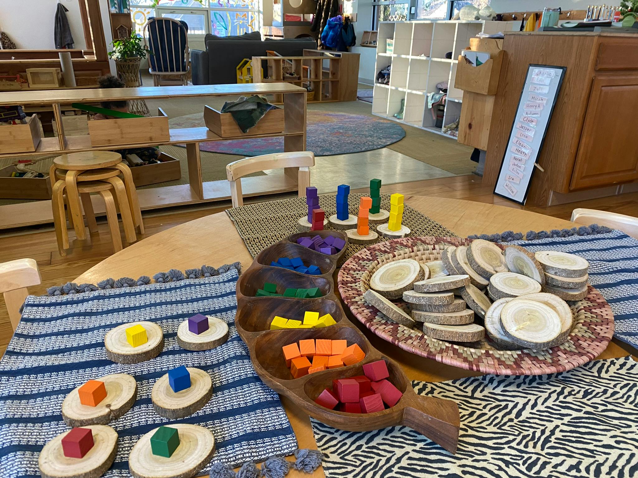 Table with wooden sorting trays and colorful blocks in a classroom