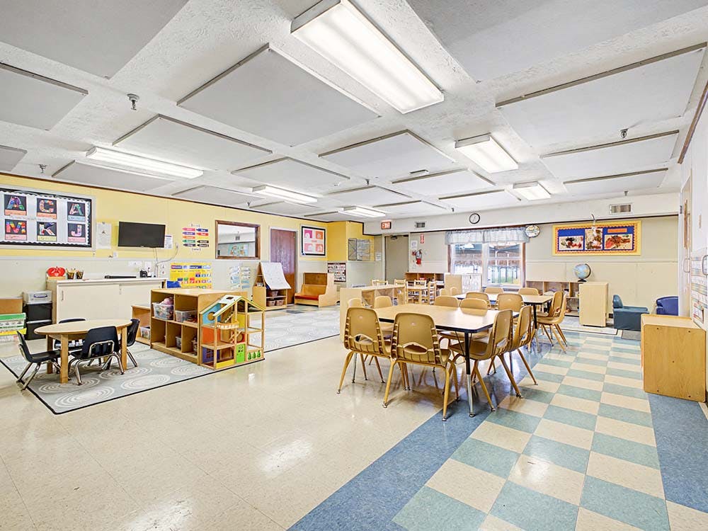 Empty classroom with small tables and chairs