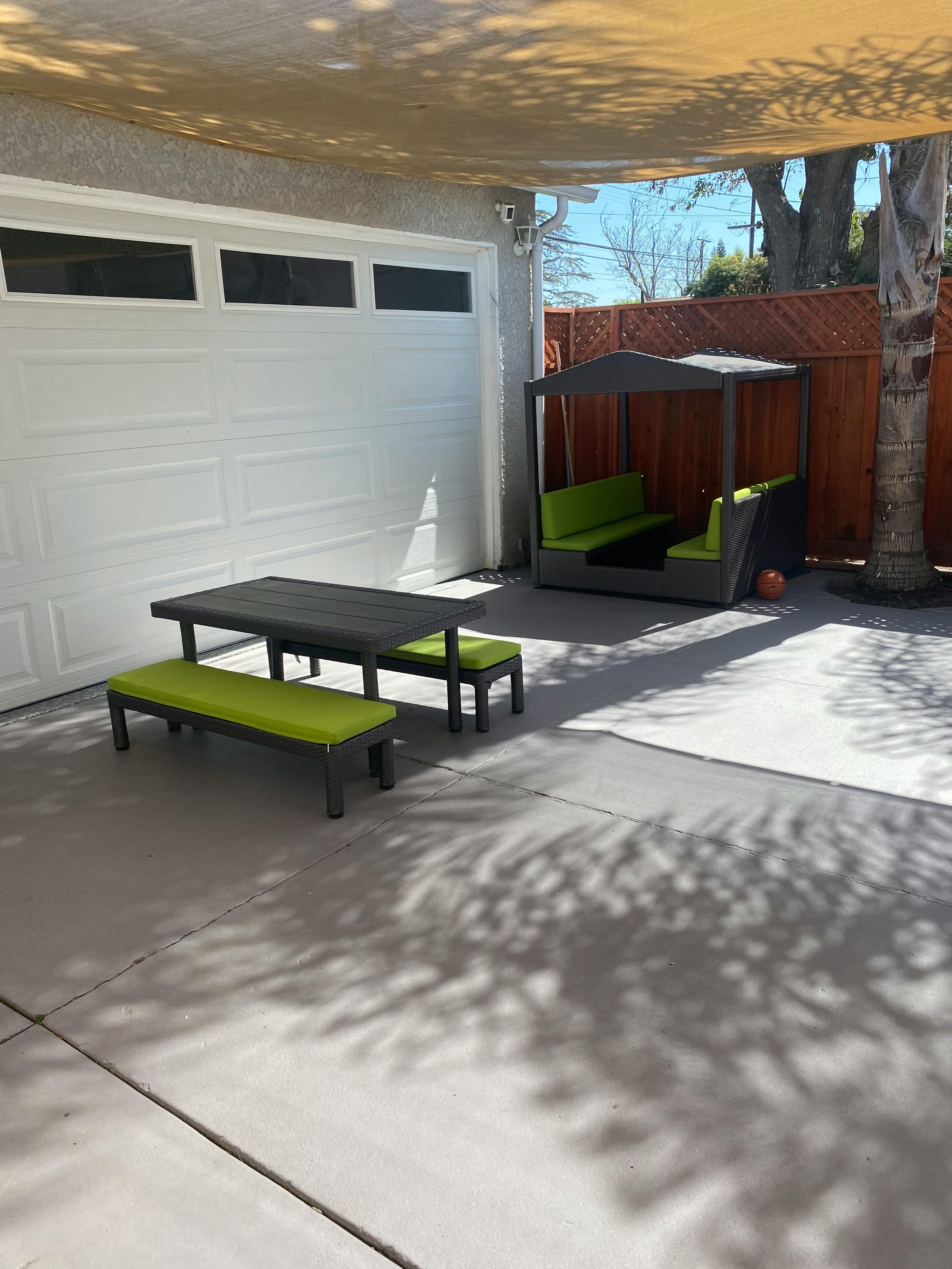 Outdoor dining set with green cushions and a covered seating area