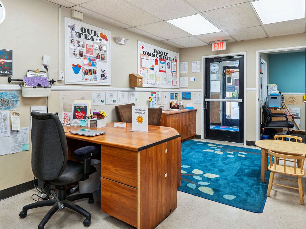 Reception desk in an office with a door and a small child's table and chairs