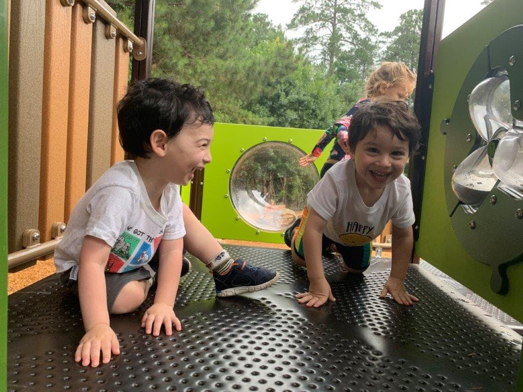 Two children playing on a playground structure