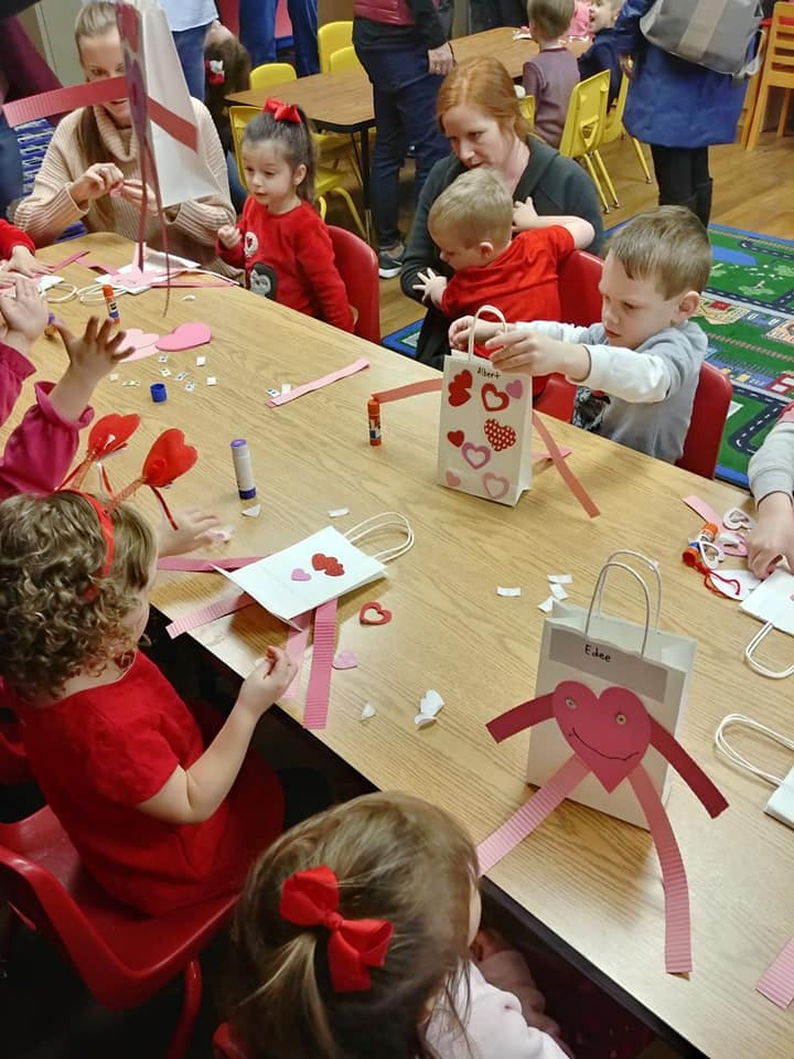 Children and adults making crafts at a table