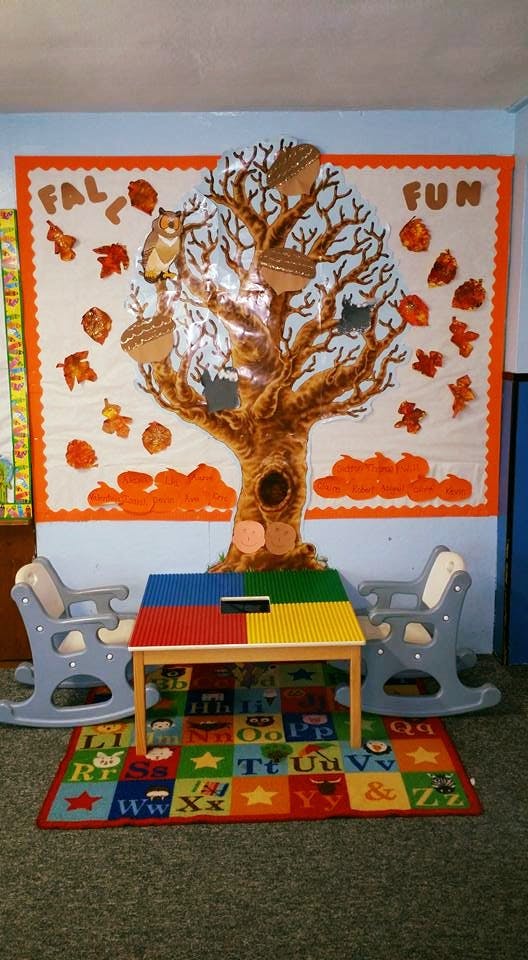 Classroom with a tree mural, two rocking chairs, and a colorful table