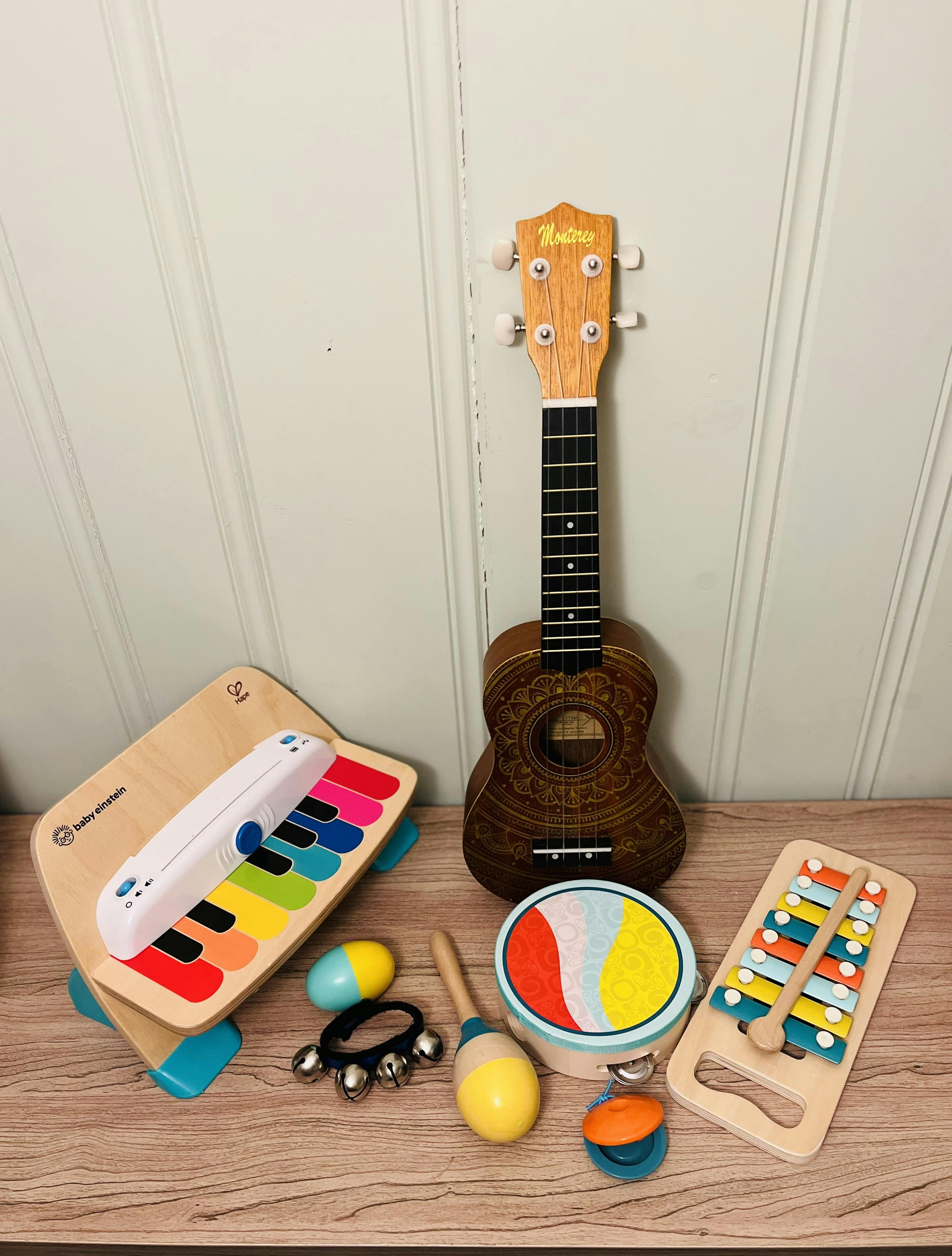 Collection of children's musical instruments including a ukulele and keyboard