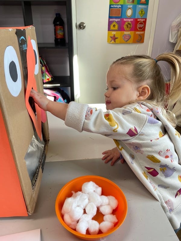 Child playing with a cardboard box craft