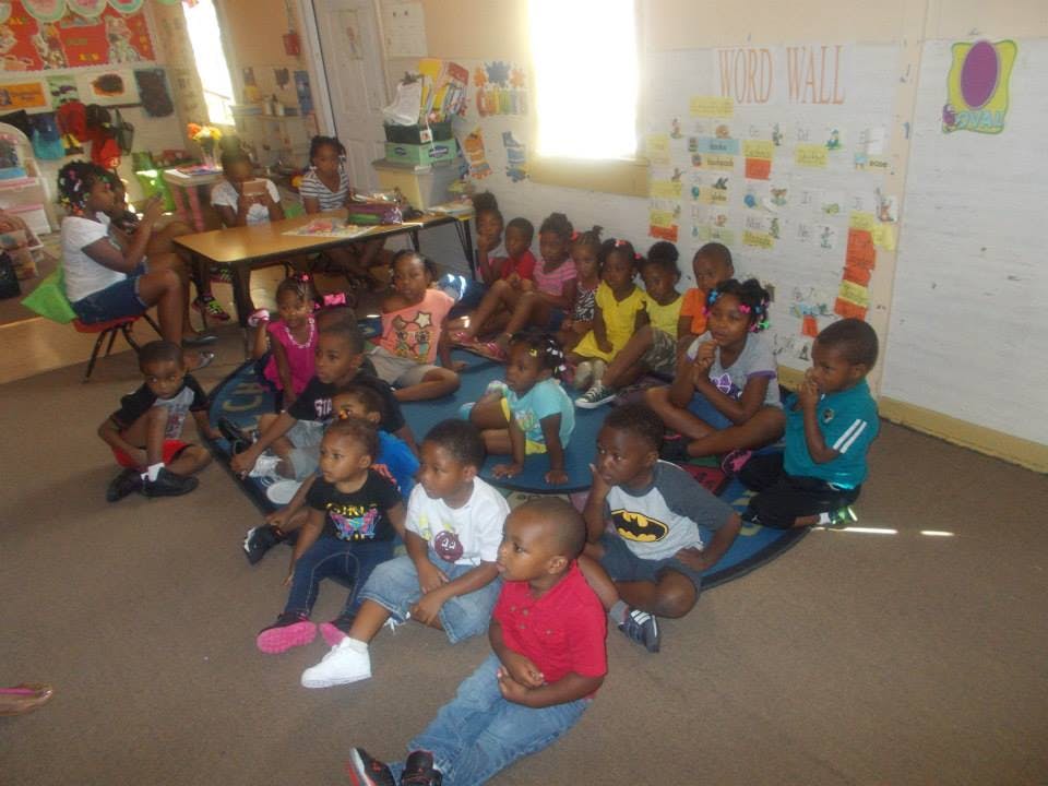 Group of children sitting on the floor in a classroom
