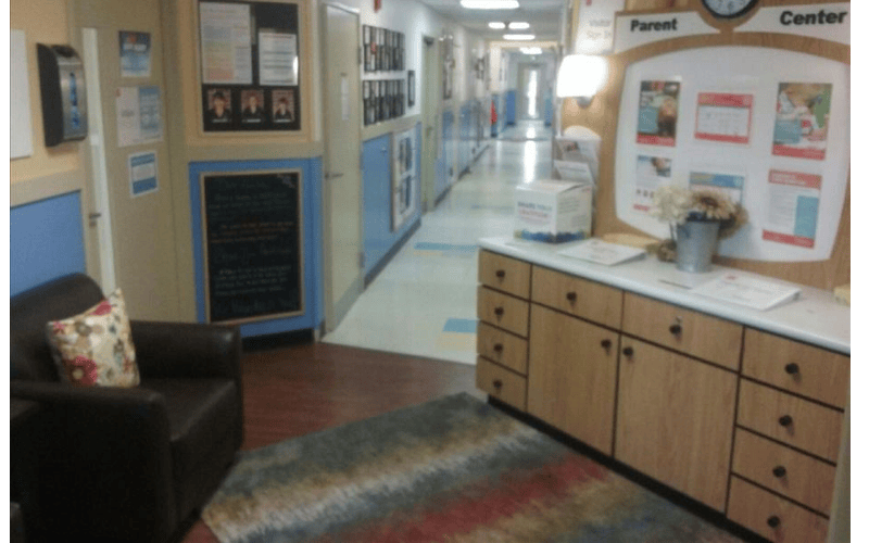 Long hallway with a seating area and parent information board