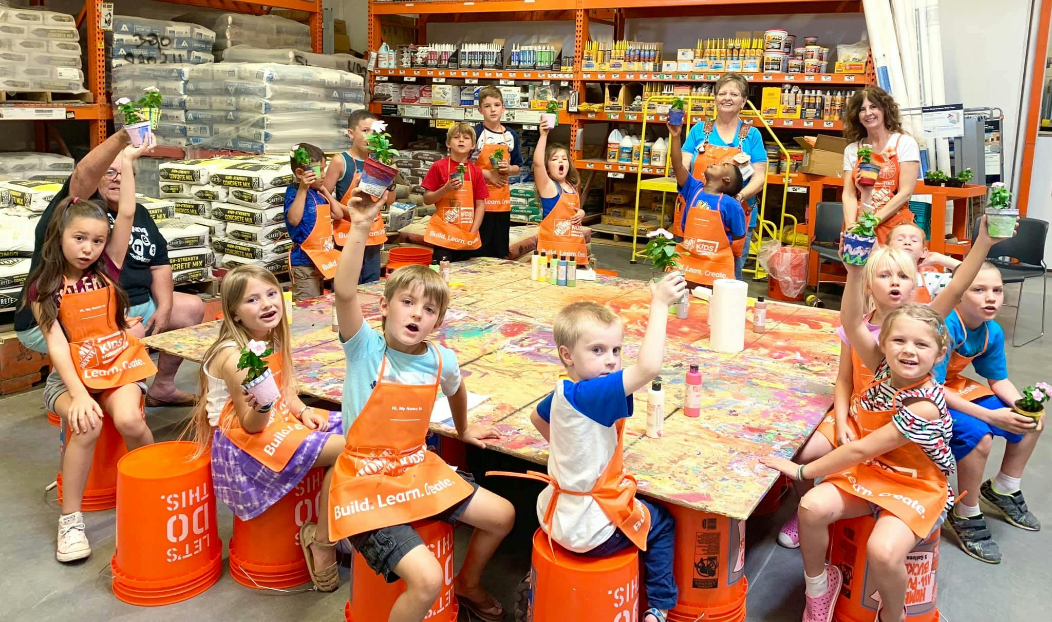Group of children and adults painting at a table