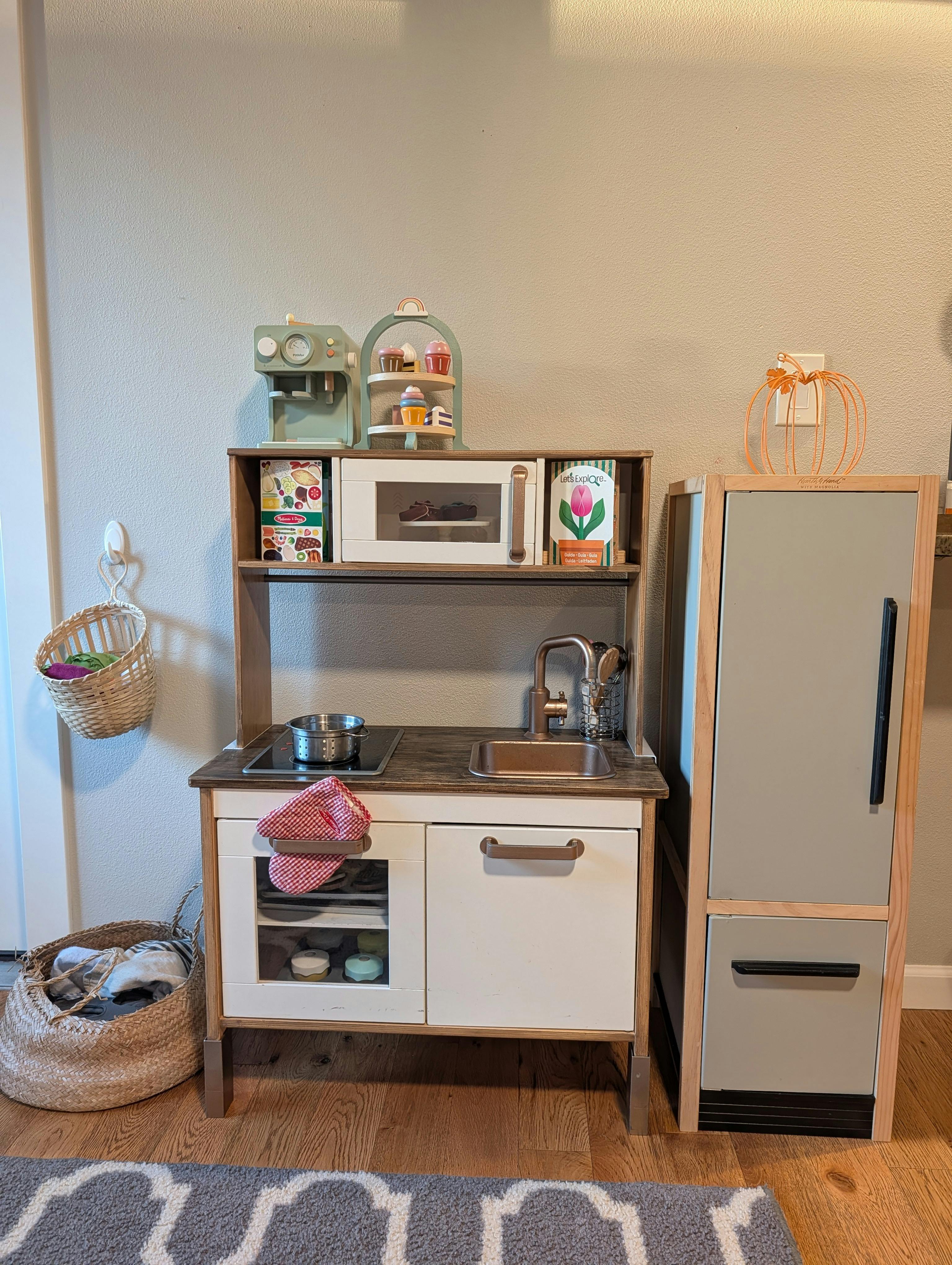 Toy play kitchen set with a stove, sink, and refrigerator