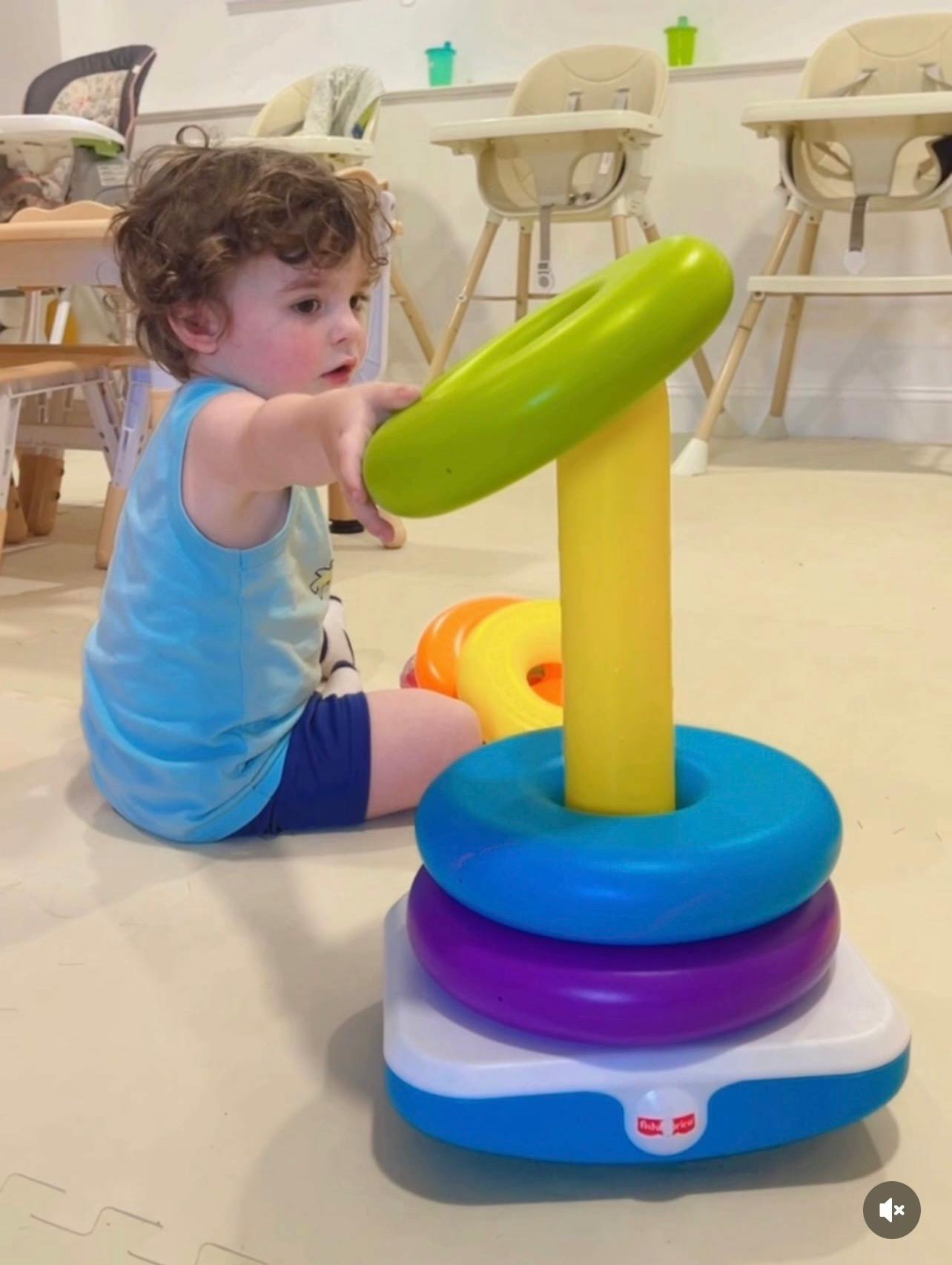 Child playing with a colorful ring stacker toy