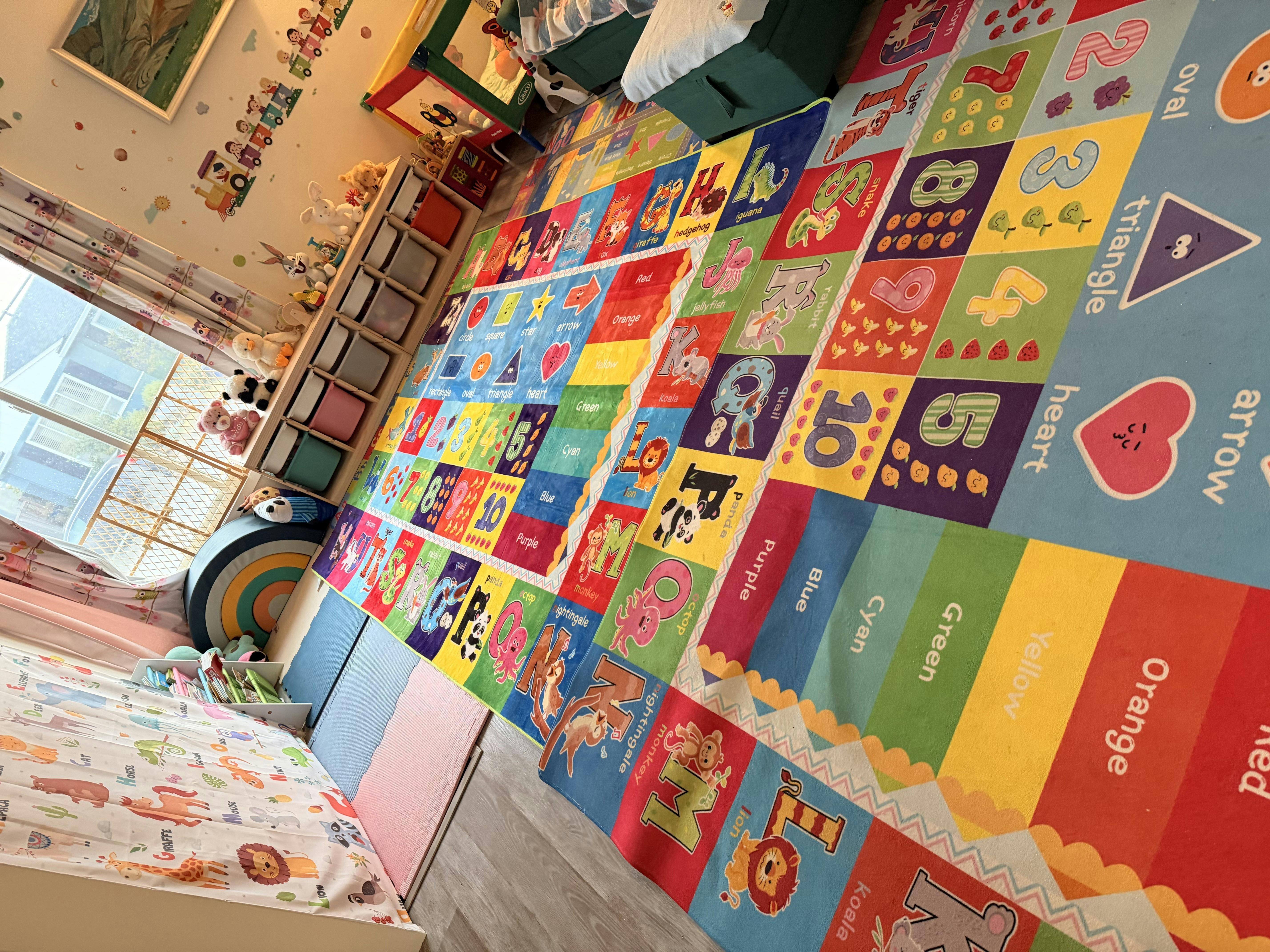 Colorful playroom with an alphabet and numbers rug on the floor, toys on shelves