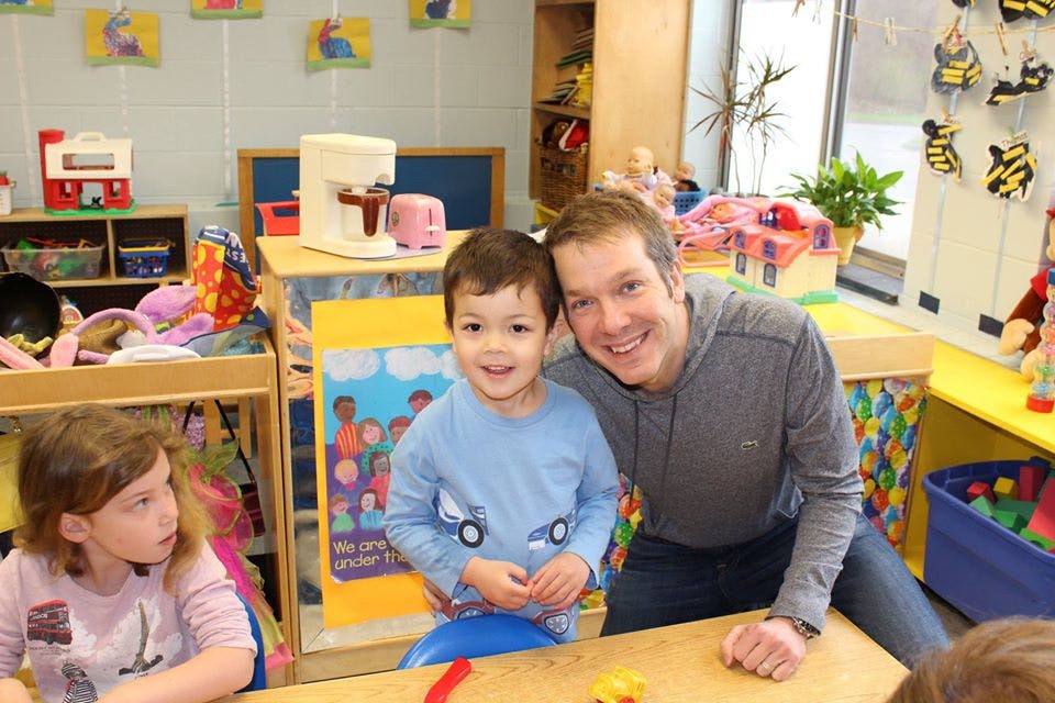 Adult and child smiling in a classroom