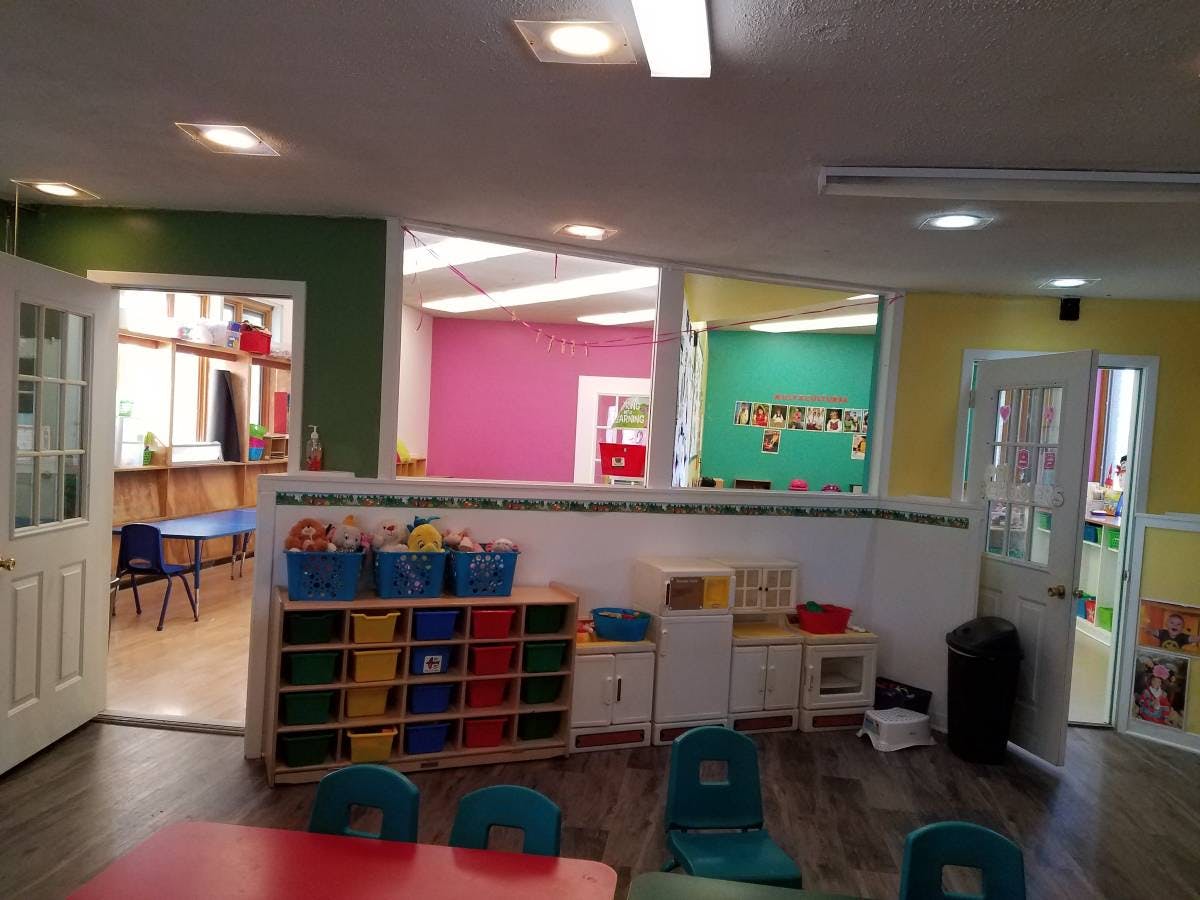 Playroom with colorful walls, storage shelves, and small tables and chairs