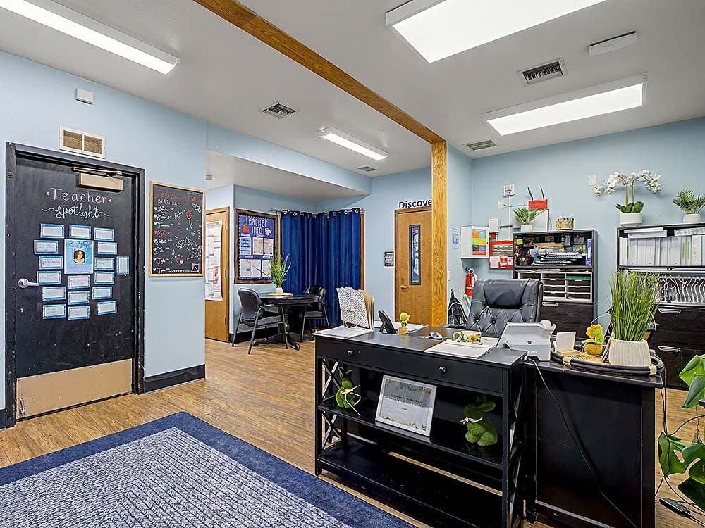 An office or classroom with a desk, file cabinets, and a bulletin board