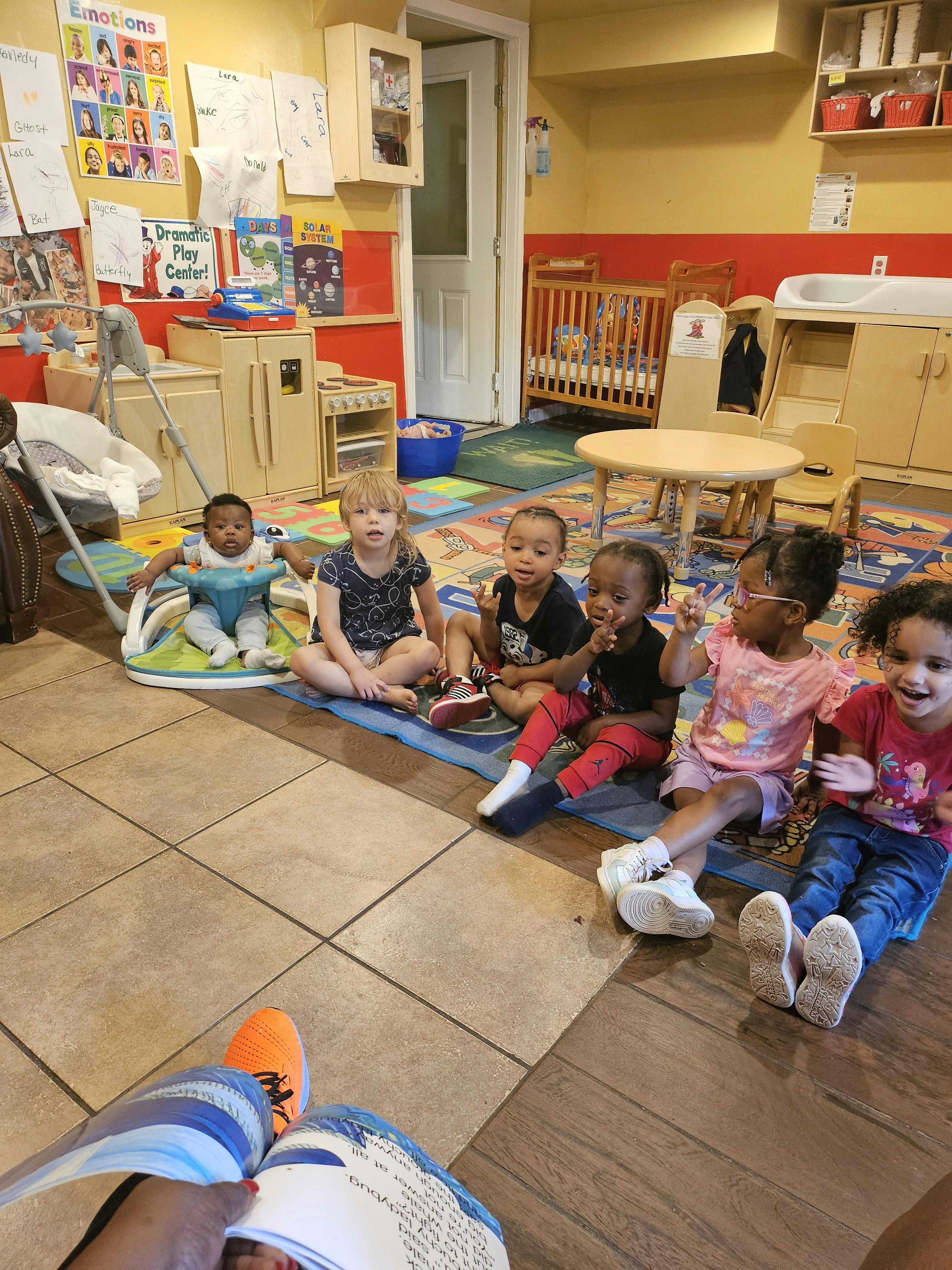 Six children sitting on the floor in a classroom